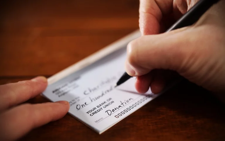 a person writing a donation check
