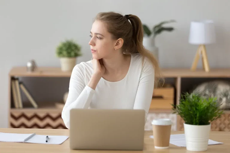 young woman on computer thinking about asking for donations